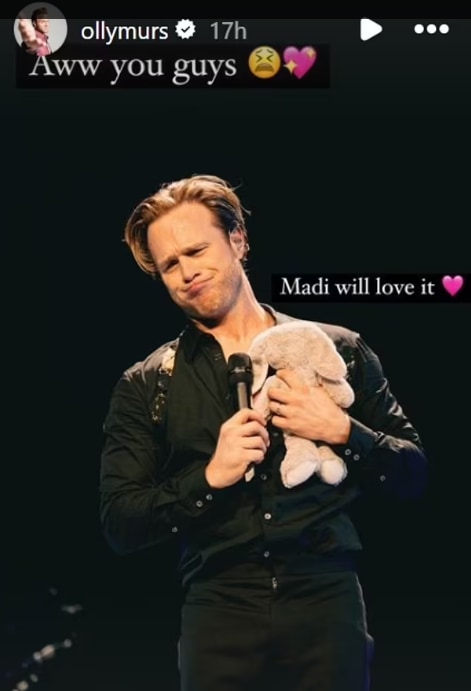 Olly on stage holding bunny stuffed toy